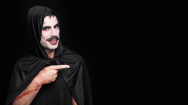 Young man with artificial scratches posing in Halloween costume