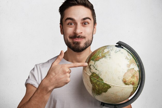 Young man with beard and globe