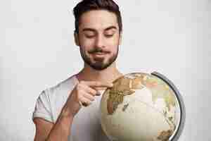 Free photo young man with beard and globe
