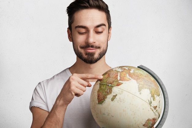 Young man with beard and globe