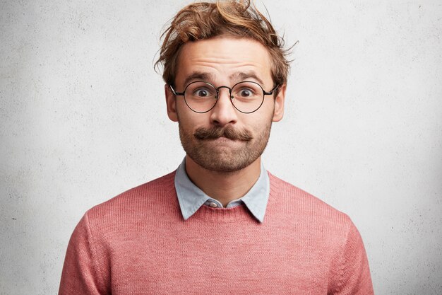 Young man with beard and round glasses