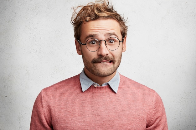 Free photo young man with beard and round glasses