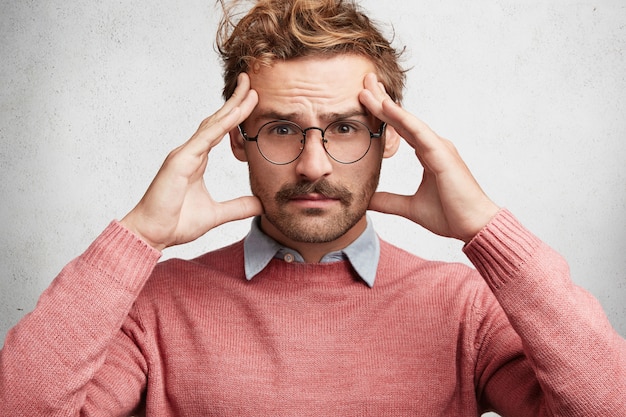 Free photo young man with beard and round glasses