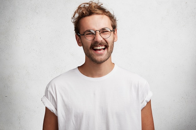 Free photo young man with beard and round glasses