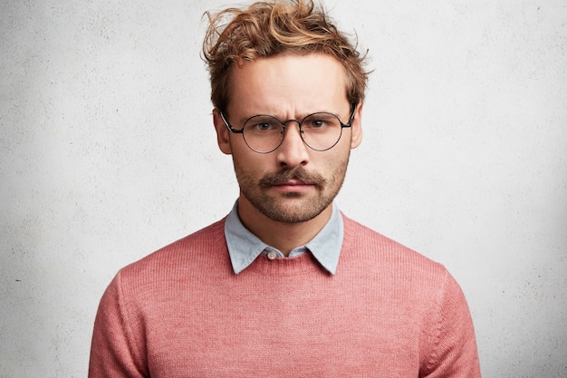 Free photo young man with beard and round glasses