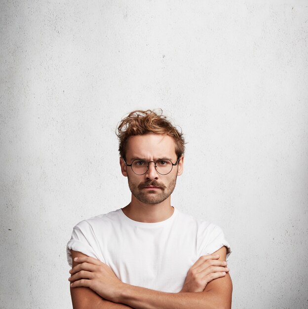 Young man with beard and round glasses