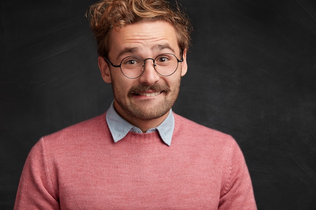 Free photo young man with beard and round glasses