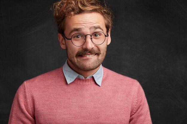 Young man with beard and round glasses