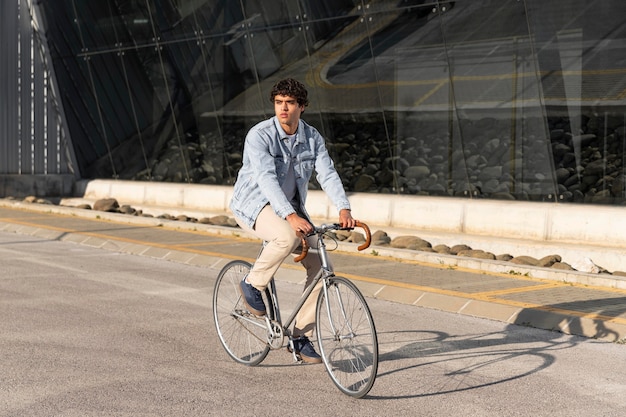 屋外で自転車を持っている若い男
