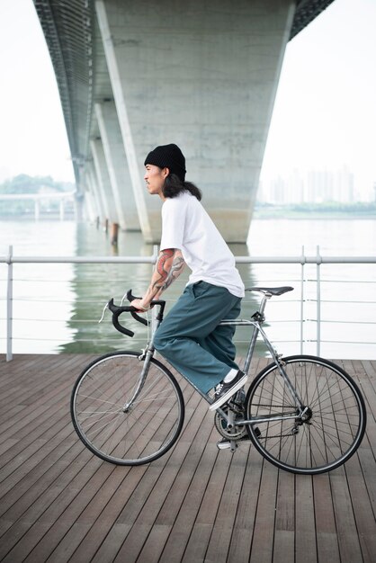 街で自転車を持っている若い男