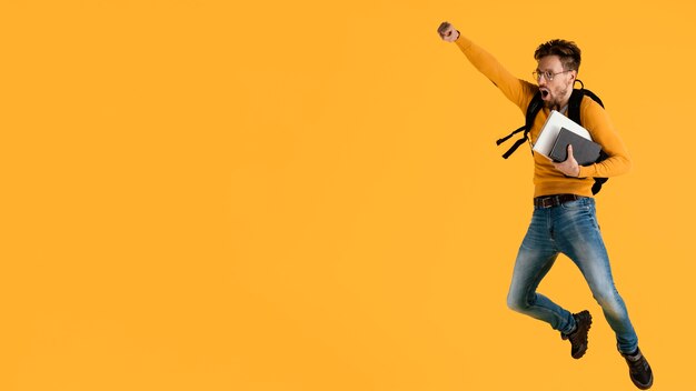 Young man with book jumping