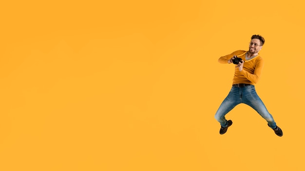 Young man with camera jumping