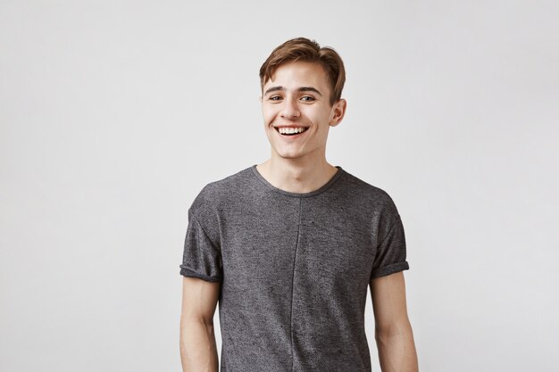 Young man with a charming smile and blue eyes posing