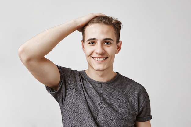 Free photo young man with a charming smile and blue eyes posing