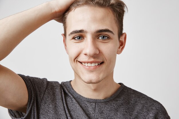 Young man with a charming smile and blue eyes posing