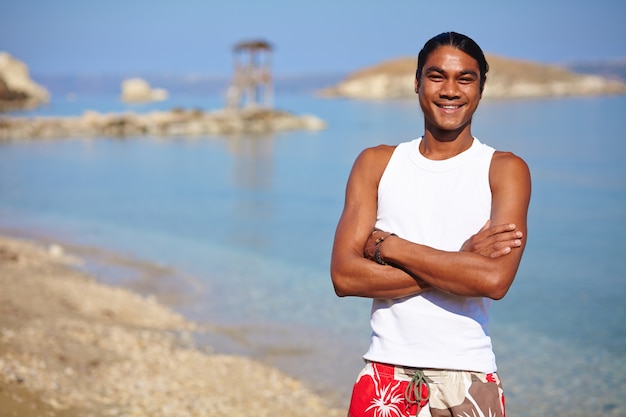 Foto gratuita giovane con le braccia incrociate sulla spiaggia