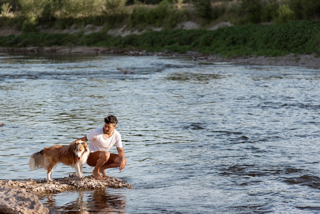 Foto gratuita giovane con cane in riva al mare