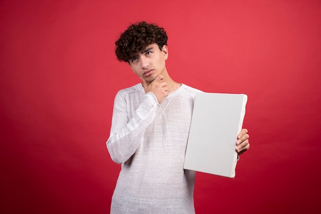 Young man with empty canvas thinking  .