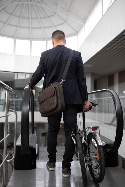 Young man with folding bike on escalator