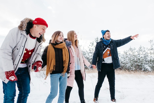 Young man with friends pointing finger at somewhere 