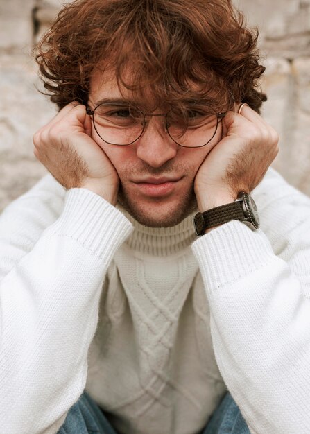 Young man with glasses posing outdoors