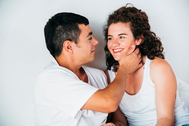 Young man with hand on happy woman neck