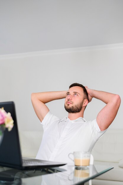 Young man with hands on head looking up