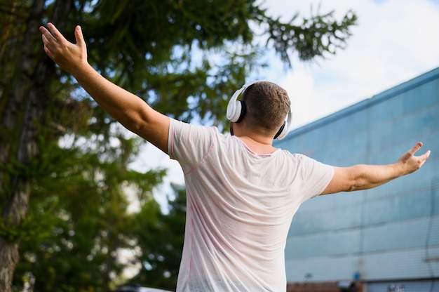 Free photo behind a young man with hands raised