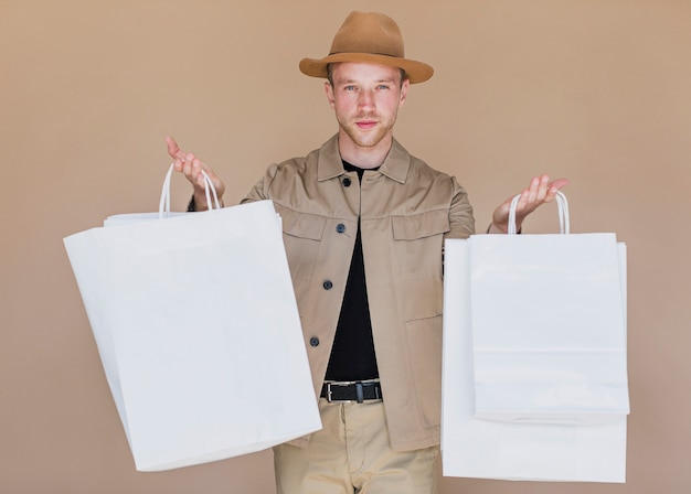 ショッピングネットを保持している帽子の若い男