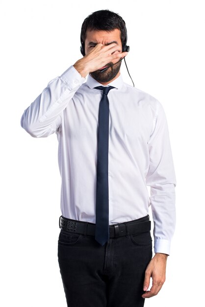 Young man with a headset doing smelling bad gesture