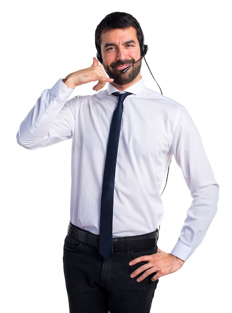Young man with a headset making phone gesture
