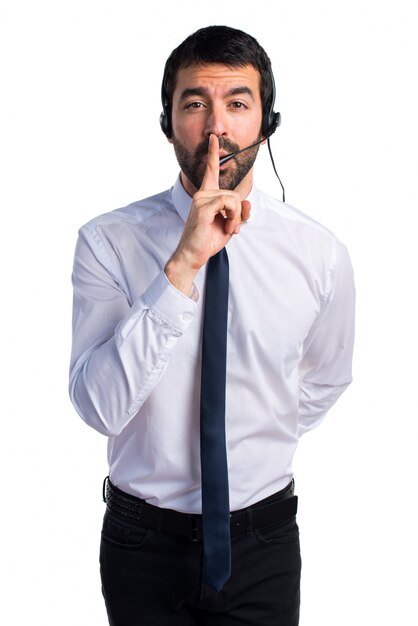 Young man with a headset making silence gesture