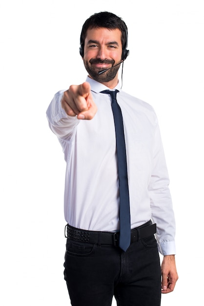 Young man with a headset pointing to the front