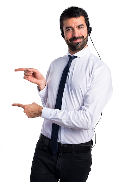 Young man with a headset pointing to the lateral