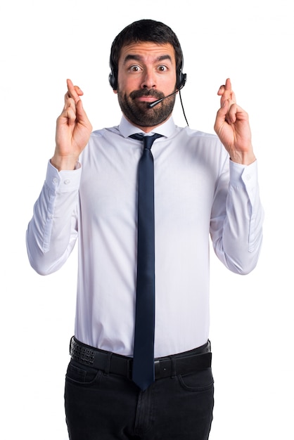 Young man with a headset with his fingers crossing