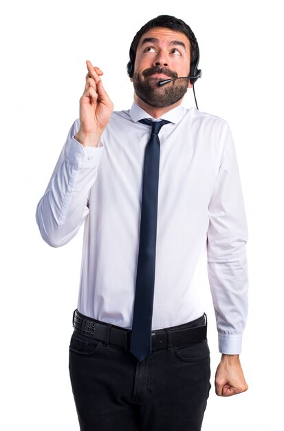 Young man with a headset with his fingers crossing