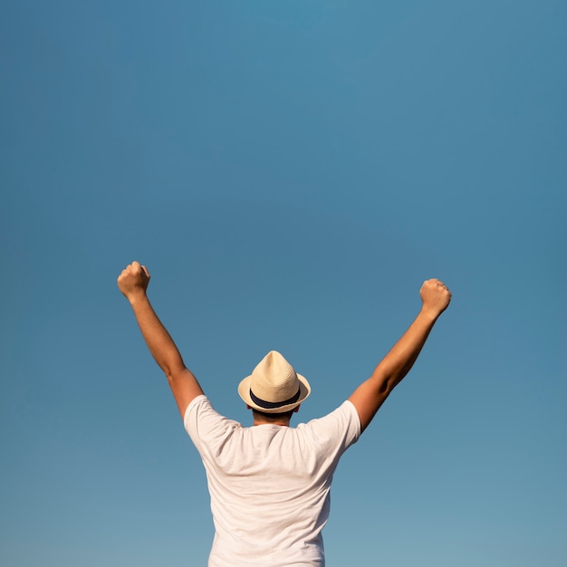 Free photo young man with his arms in the air