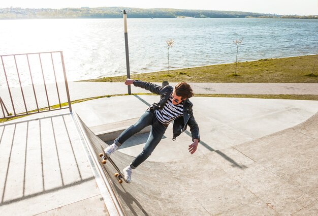 Young man with his skateboarding at the skate park