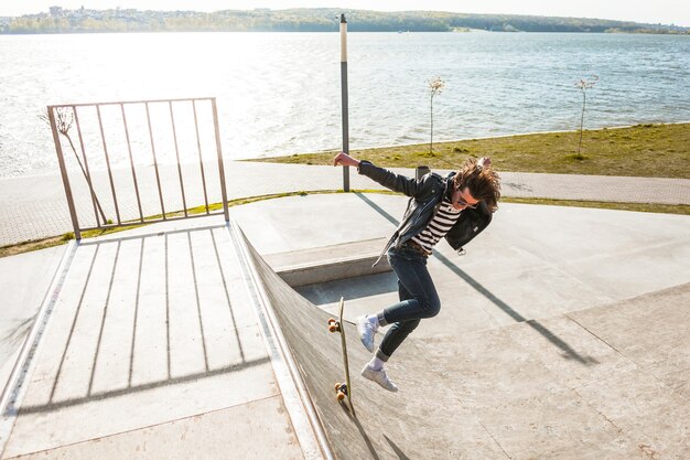 Young man with his skateboarding at the skate park