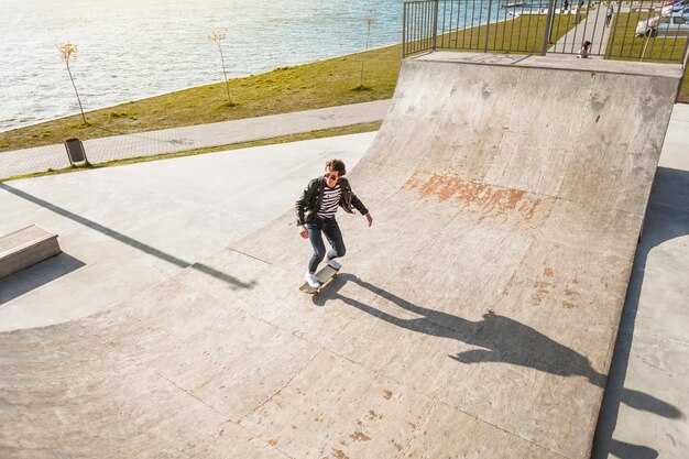Young man with his skateboarding at the skate park