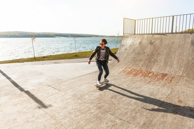 Young man with his skateboarding at the skate park