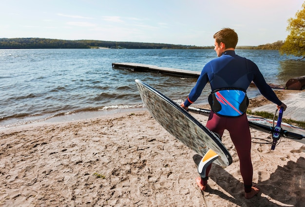 Young man with kitesurf board