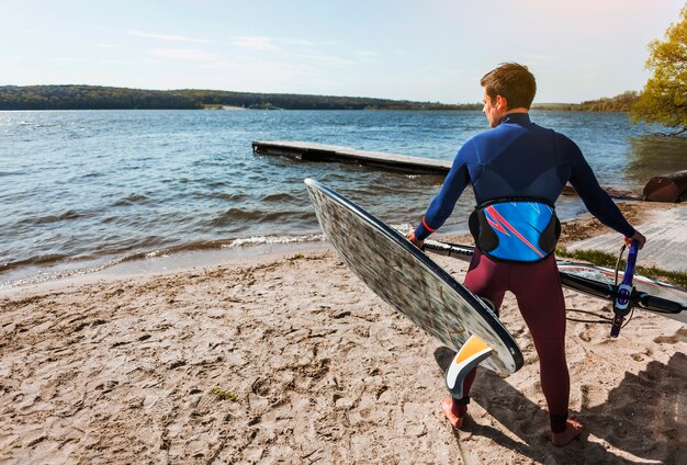 Young man with kitesurf board