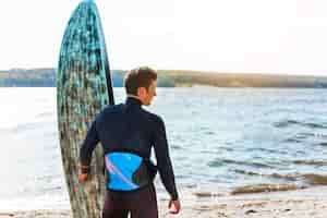 Free photo young man with kitesurf board