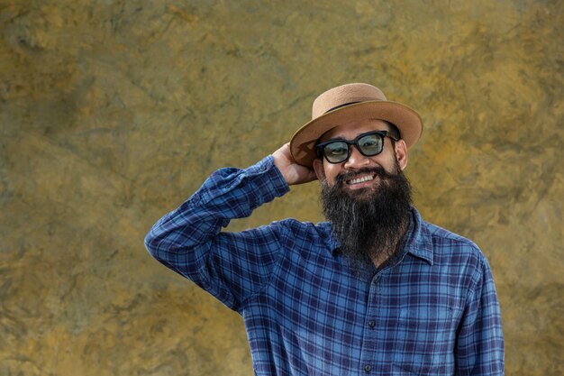 Young man with a long beard wearing a hat and glasses