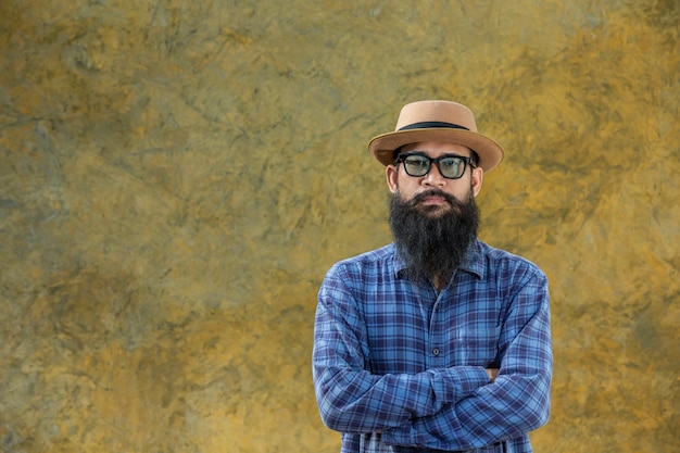 Young man with a long beard wearing a hat and glasses