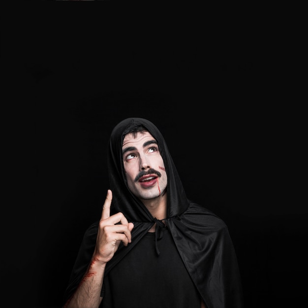 Young man with painted scratches on pale face posing in Halloween costume