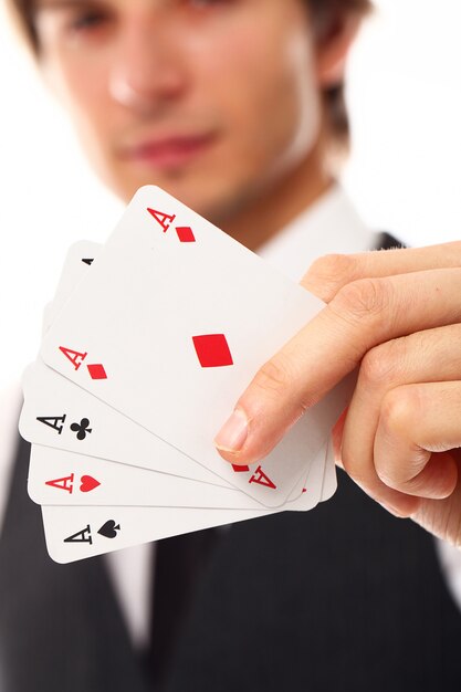 Young man with poker cards, close up