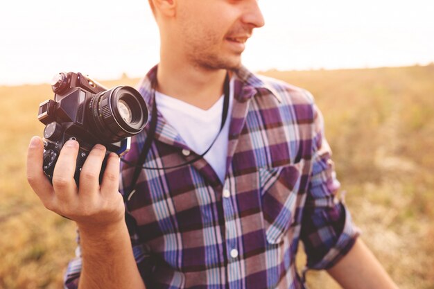 Young Man with retro photo camera outdoor hipster Lifestyle