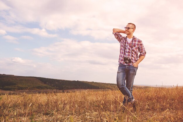 Young Man with retro photo camera outdoor hipster Lifestyle